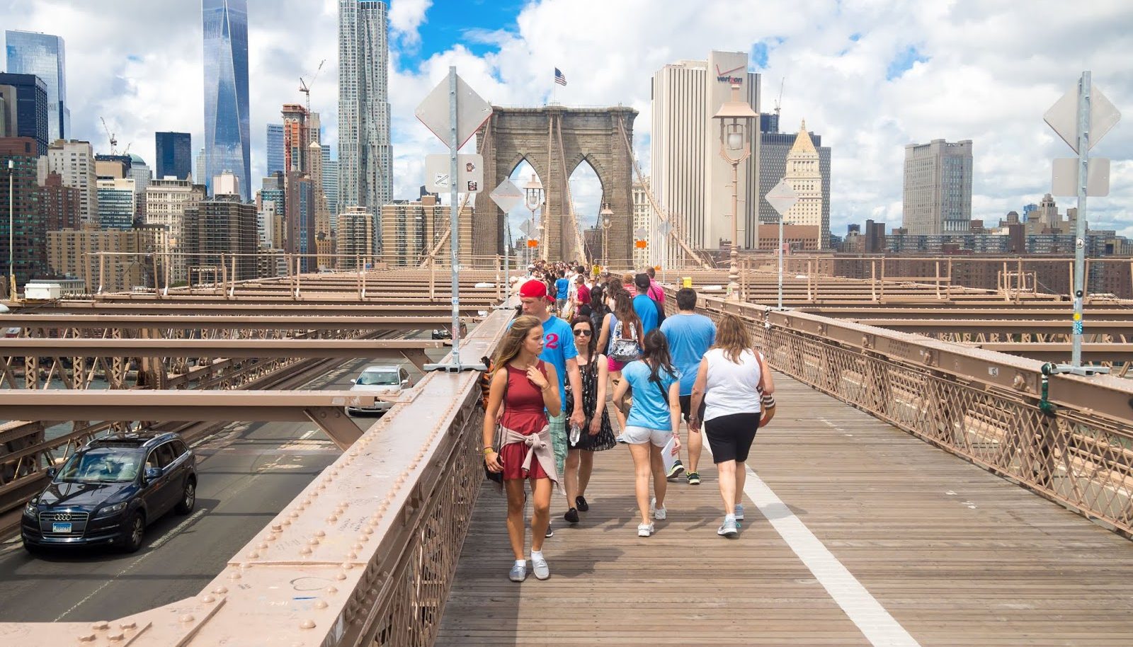 NEW YORK,USA- AUGUST 20,2015 : Tourists at the Brooklyn Bridge with the Manhattan skyline on the background